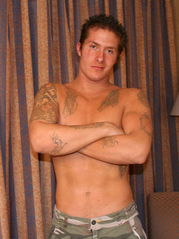 Topless stud Dallas Adams demonstrates his tattoos in the comfort of his home